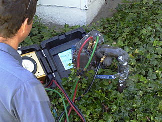 San Marcos sprinkler repair technician examines a backflow prevention device