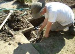 Irrigation repair contractor works on a valve box